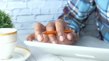 Man's hand using digital tablet with tea cup on table video