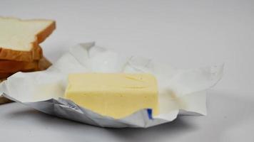 slice of a butter on a paper on table video