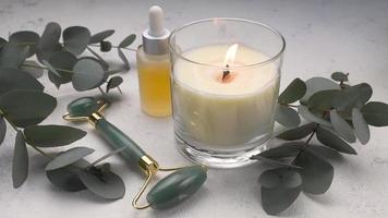 spa tratamiento concepto. natural spa productos cosméticos productos con eucalipto aceite, masaje jade rodillo, eucalipto hoja. video