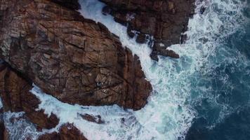 Top Down View Of Foamy Waves Splashing On Rugged Cliffs In Arteixo, Spain - drone shot video