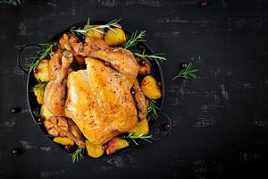 Baked turkey or chicken. The Christmas table is served with a turkey, decorated with bright tinsel. Fried chicken. Table setting. Christmas dinner. Top view photo