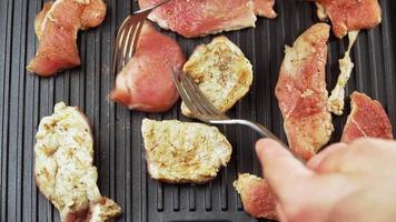 gekookt rundvlees steak of varkensvlees ribben, roosteren vlees Aan een metaal elektrisch grillen. langzaam beweging. dichtbij omhoog. video
