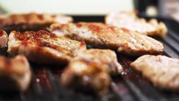 cucinato Manzo bistecca o Maiale costole, tostatura carne su un' metallo elettrico griglia. lento movimento. vicino su. video