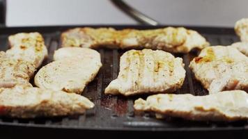 Cooked beef steak or pork ribs, toasting meat on a metal electric grill. Slow motion. Close up. video