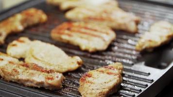 Cooked beef steak or pork ribs, toasting meat on a metal electric grill. Slow motion. Close up. video