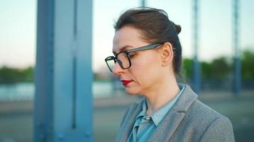 Woman in a coat walking around the city in the early morning with smartphone video