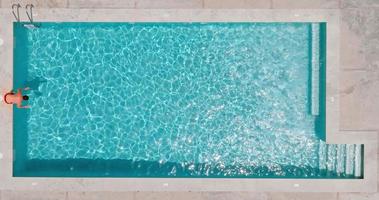 aéreo Visão Como uma homem mergulhos para dentro a piscina e nada. lento movimento video