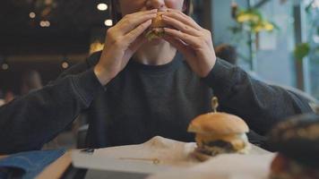 mulher come uma Hamburger dentro uma cafeteria video