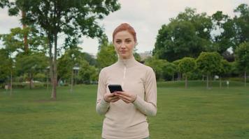 femmina assunzione rompere a partire dal jogging e utilizzando smartphone video