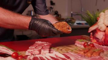 Man hands placing a roll of home-made sausage ring on a wooden cutting board. video