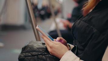 Side view of woman surfing online on smartphone in public transport. video