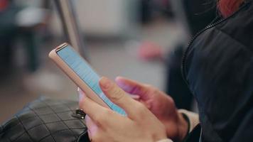 vicino su di donna mani scorrimento smartphone nel pubblico trasporto. video