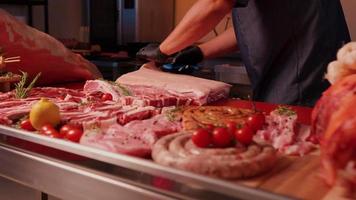 Butchers shop man hands removing the fat from raw pork meat. video