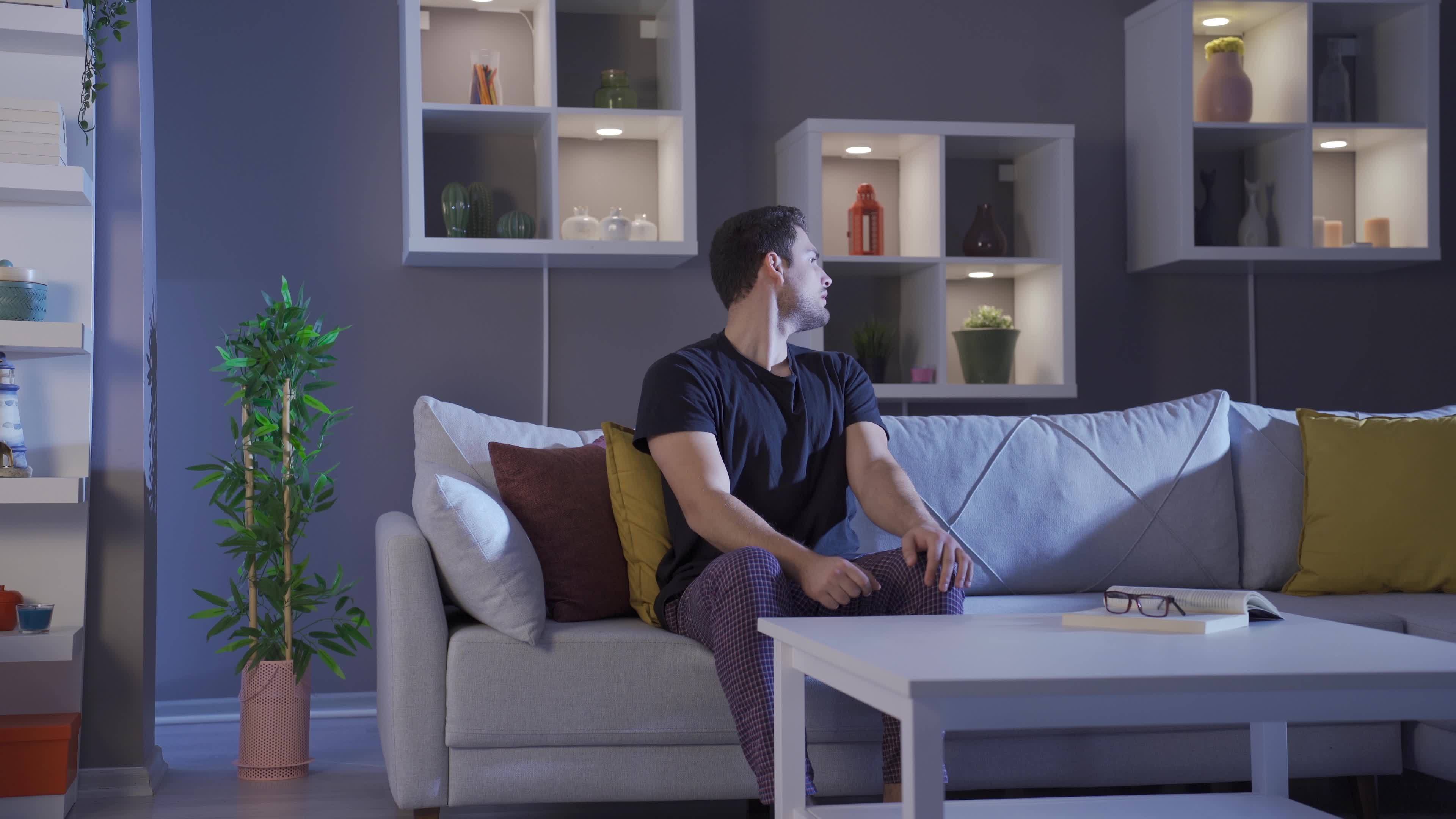 Man alone at home scared in the dark. A young man who is afraid alone