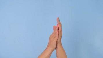 Female hands clapping and pointing with index finger on pastel blue background in studio. Pack of Gestures movements and body language. video