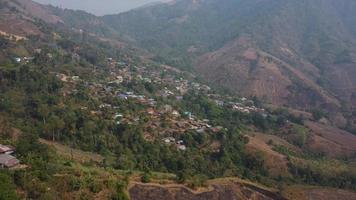 aéreo ver desde un zumbido de un pequeño pueblo en el montañas. colina tribu casa video