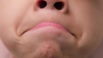 Cute little girl compress one's lips close. Close-up portrait of beautiful girl showing funny face isolated on pink background. Concept of good health in childhood. video