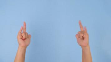 Female hand showing I Love You sign isolated on pastel blue background in studio. Pack of Gestures movements and body language. Love hand sign video