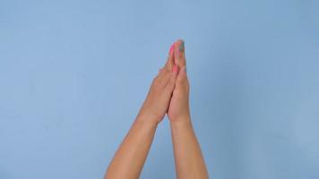 kvinna händer applåder och pekande med index finger på pastell blå bakgrund i studio. packa av gester rörelser och kropp språk. video