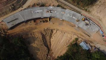 Aerial view of development of new road construction or overpass under construction. Top view from a drone above road construction workers among the mountains. video