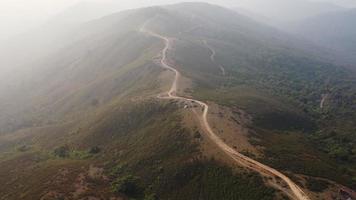 Aerial view of treeless mountain range destroyed by humans. Mountains covered in haze from burning forests.Areas with dense smog and covered with PM2.5. Air pollution and ecological problems video