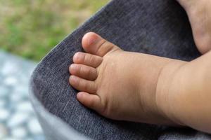 cerca arriba de bebé minúsculo pies. bebé pie en paseante. infantil chico minúsculo pies. foto