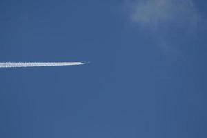 un avión y estelas de vapor en el cielo foto