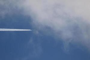 un avión y estelas de vapor en el cielo foto