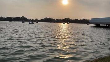 Bangkok, Thailand. March 19, 2023. View of the sunset of the Lake with spinning duck boat at public park Suan Luang Rama IX. Thailand public park. video