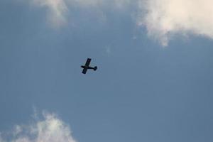 Small plane flying on a blue sky photo