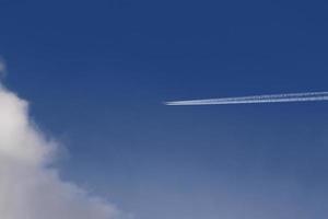 A plane and vapor trails in the sky photo