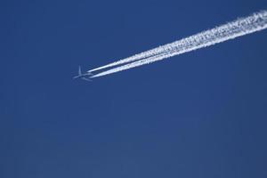 un avión y estelas de vapor en el cielo foto