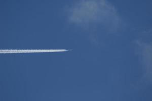 un avión y estelas de vapor en el cielo foto