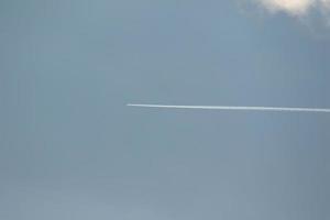A plane and vapor trails in the sky photo