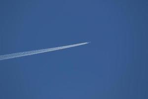 un avión y estelas de vapor en el cielo foto