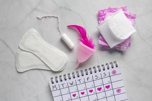 menstruación calendario con algodón tampones mujer higiene proteccion. mujer crítico días. conjunto de De las mujeres medio personal higiene, femenino higiene almohadillas, taza, menstruación foto