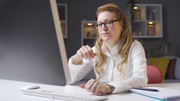 nachdenklich reifen Frau Arbeiten im Zuhause Büro. reifen Frau funktioniert von Zuhause und ist nachdenklich während tun Computer Operationen . video