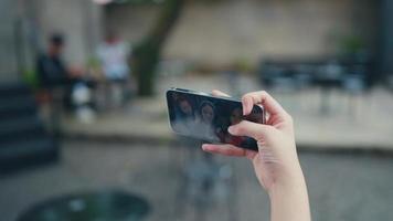 mano participación un inteligente teléfono mientras tomando un selfie de un grupo de mujer video