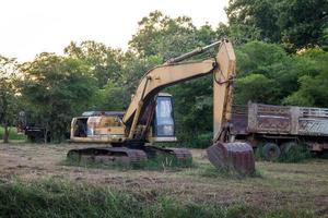 old backhoe on construction site in the green fields photo