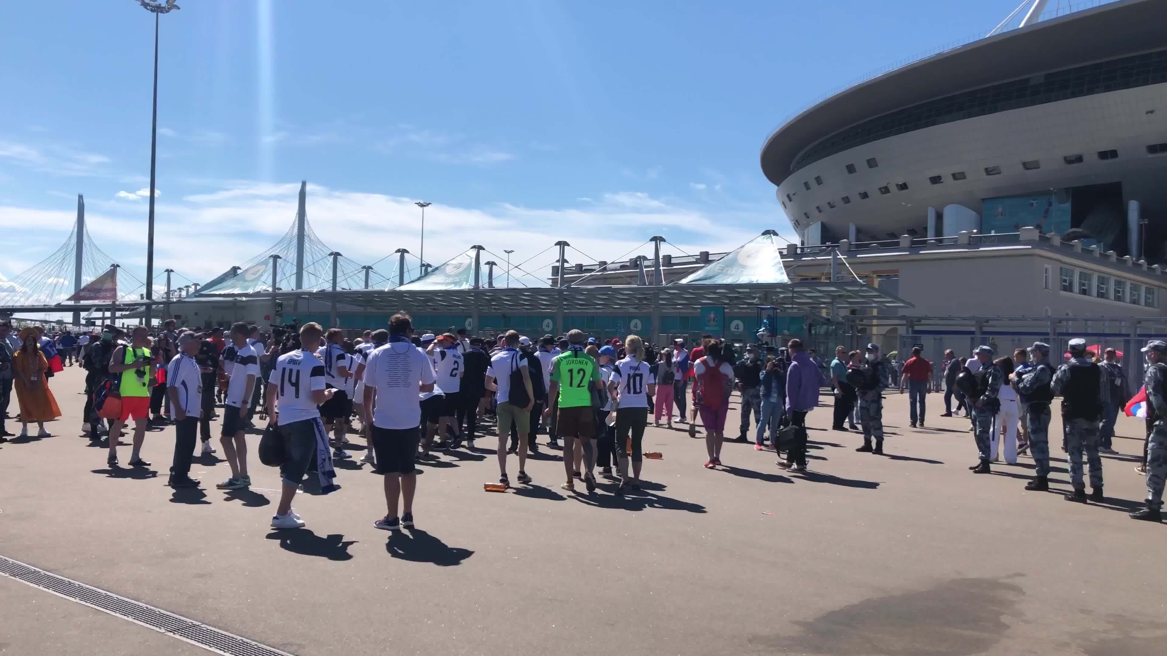 Football fans walk around the entrance to the football stadium