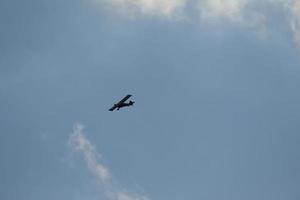 Small plane flying on a blue sky photo