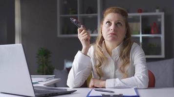 personnes âgées affaires femme est réfléchi et dans chercher de idées. personnes âgées affaires femme travail dans Accueil Bureau en pensant de Créatif idées. réflexion. video