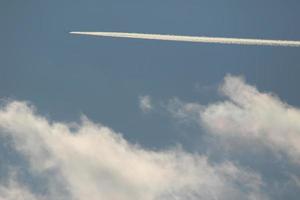 un avión y estelas de vapor en el cielo foto