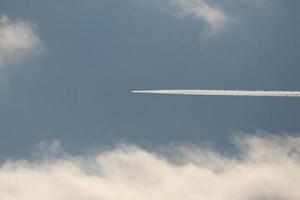 un avión y estelas de vapor en el cielo foto