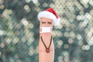 Finger art of lonely woman in medical mask from COVID-2019. Concept people celebrate Christmas in new year hat. photo