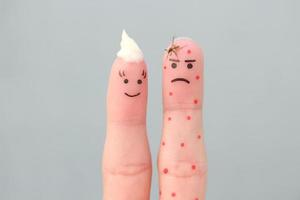 Fingers art of couple. Concept of man being bitten by mosquito and woman is anointed with protective cream. photo