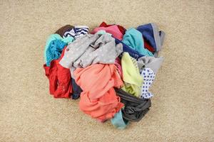 Pile of carelessly scattered clothes on floor. Top view. photo