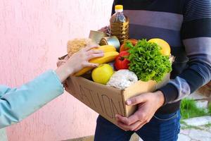 hombre sostiene donación caja con alimento. foto