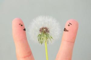 Fingers art of happy couple. Man is giving flowers to woman. photo