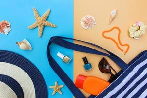 Beach bag, sun hat, sunblock, beads, shells, sunglasses, hair scrunchies, nail polish. Top view. photo